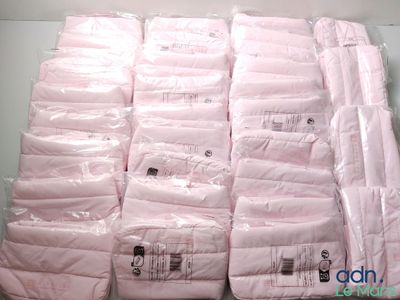 une pile de linge de lit rose posée sur une table