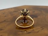 an image of a gold ring with a black diamond
