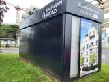 a bus stop that has a sign on the side of it