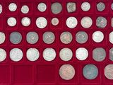 un assortiment d'objets en argent et de pièces d'argent présentés dans une vitrine rouge