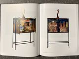 a book opened to show a picture of a woman and a cabinet