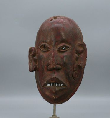 sculpture représentant le visage d'un homme, posée sur un socle, avec un ciel gris en arrière-plan