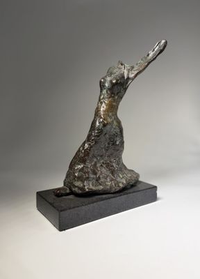 a bronze sculpture of a dog on a black base