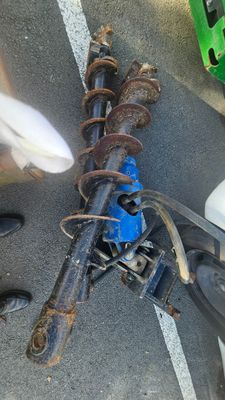 une personne debout à côté d'un vélo cassé dans la rue