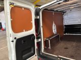 a white van with a brown door open in a garage
