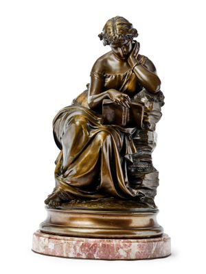 l'image d'une statue de bronze représentant une femme assise sur un rocher