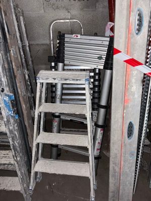 une échelle qui se trouve à côté d'une autre échelle dans une pièce