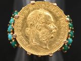 Gros plan sur une bague ornée d'une pièce d'or