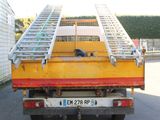 a yellow truck with a ladder on the back of it