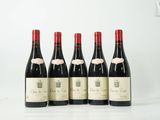 quatre bouteilles de vin sont alignées sur une table