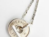 a close up of a coin on a chain on a white surface