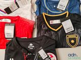 a lot of different soccer jerseys on a table