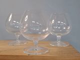 quatre verres à vin vides posés sur une table en bois