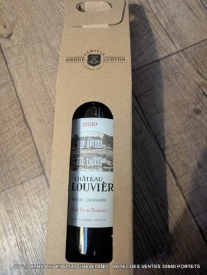 une bouteille de vin dans une boîte en carton posée par terre