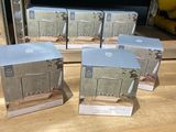 trois micro-ondes posés sur une table en bois devant un four à micro-ondes