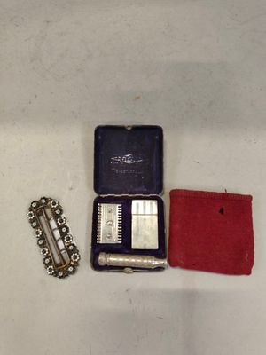 a small case with a razor, razor blade, and other items