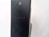 the back of a black cell phone sitting on top of a white surface
