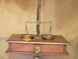 une photo d'une balance posée sur une table, sur laquelle se trouve un bol de fruits