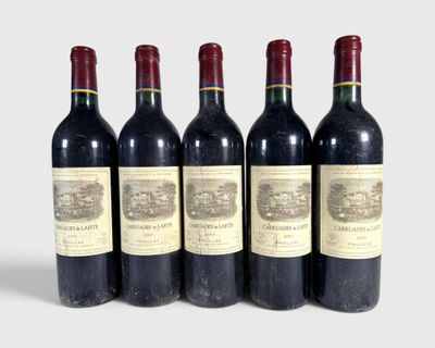 six bottles of wine are lined up in a row on a white surface
