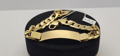 un gros plan d'une boîte sur laquelle est posé un bracelet en or
