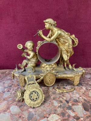 a statue of a woman and two children playing with a clock