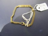 un bracelet en or muni d'une plaque, posé sur une table