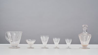 six glasses and a decanter sitting on a table
