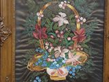 a picture of a painting of a basket of flowers on a easel