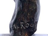 a bronze statue of a man ' s head on a black base