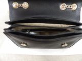 black leather purse with gold hardwares on a white background