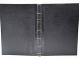 un vieux livre noir avec des bordures dorées sur fond blanc