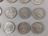 several different types of coins are arranged on a white surface