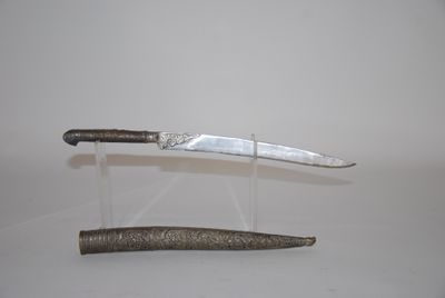 a knife on a stand next to a knife on a table