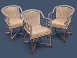 trois fauteuils en osier avec accoudoirs et pieds, sur fond bleu
