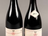 deux bouteilles de vin rouge posées l'une à côté de l'autre sur une table