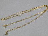 gros plan d'un collier en or auquel est attachée une chaîne