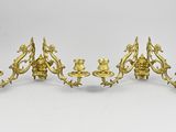 un ensemble de quatre bougeoirs en laiton ancien sur fond blanc