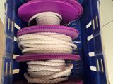 une corde violette et blanche dans un récipient en plastique muni de couvercles violets