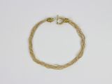 une image représentant un bracelet muni d'un fermoir en or sur fond blanc