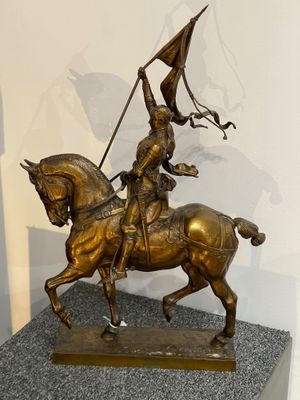 statue en bronze représentant un homme à cheval tenant un drapeau