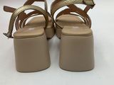 a close up of a pair of beige sandals on a white surface