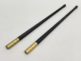 a pair of black and gold sticks sitting on top of a white table