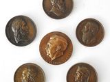 six different types of bronze coins on a white surface