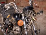 a black motorcycle parked in a garage with a brick wall behind it