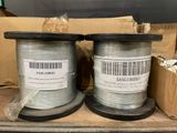 two spools of silver colored wire are on a table