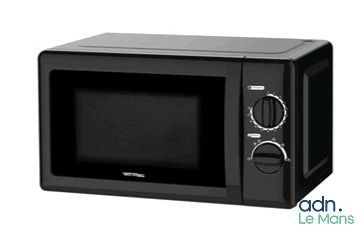 un four à micro-ondes noir posé sur une table blanche
