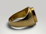 a close up of a gold ring on a white surface