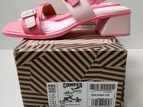 the pink and white sandals are on top of a cardboard box