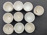 six white bowls sitting on top of a black table next to each other