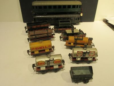 several toy trains are lined up on a table with a cell phone